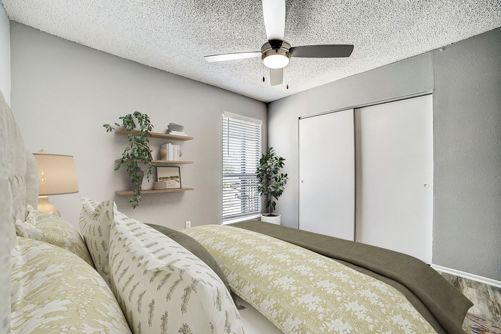 a bedroom with a bed and a ceiling fan