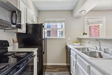 a kitchen with black appliances and white cabinets