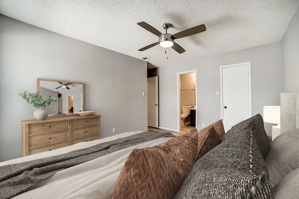 a bedroom with a large bed and a ceiling fan
