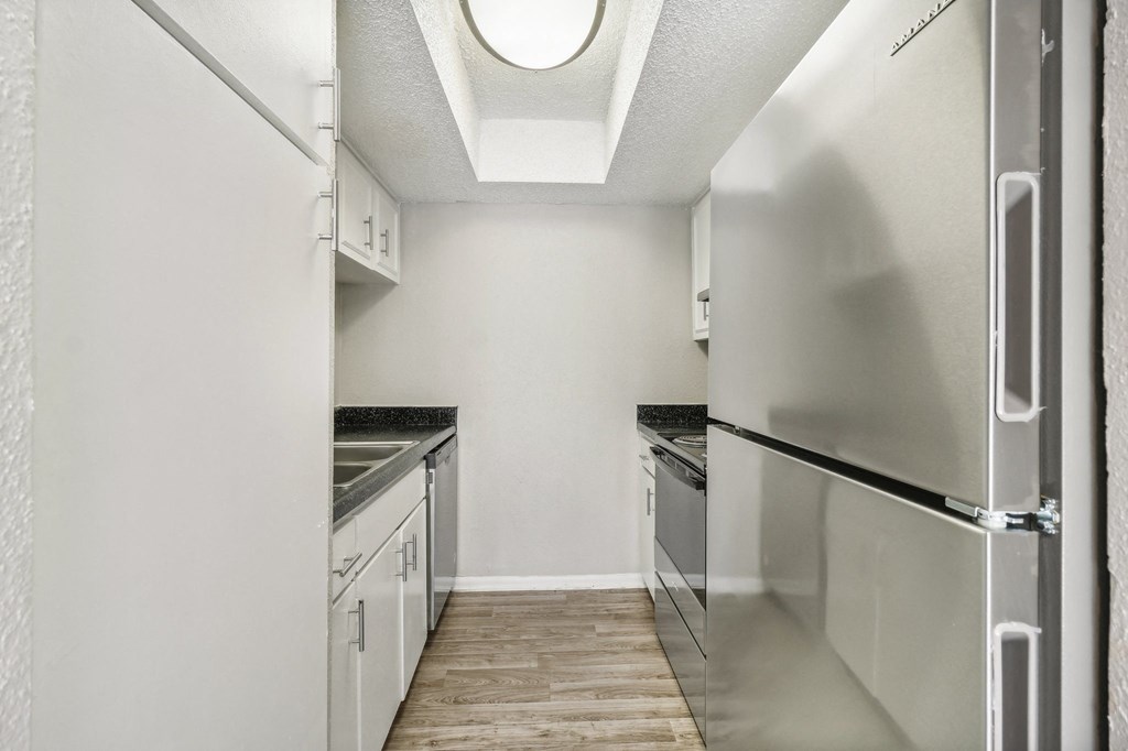 a kitchen with white cabinets and stainless steel appliances