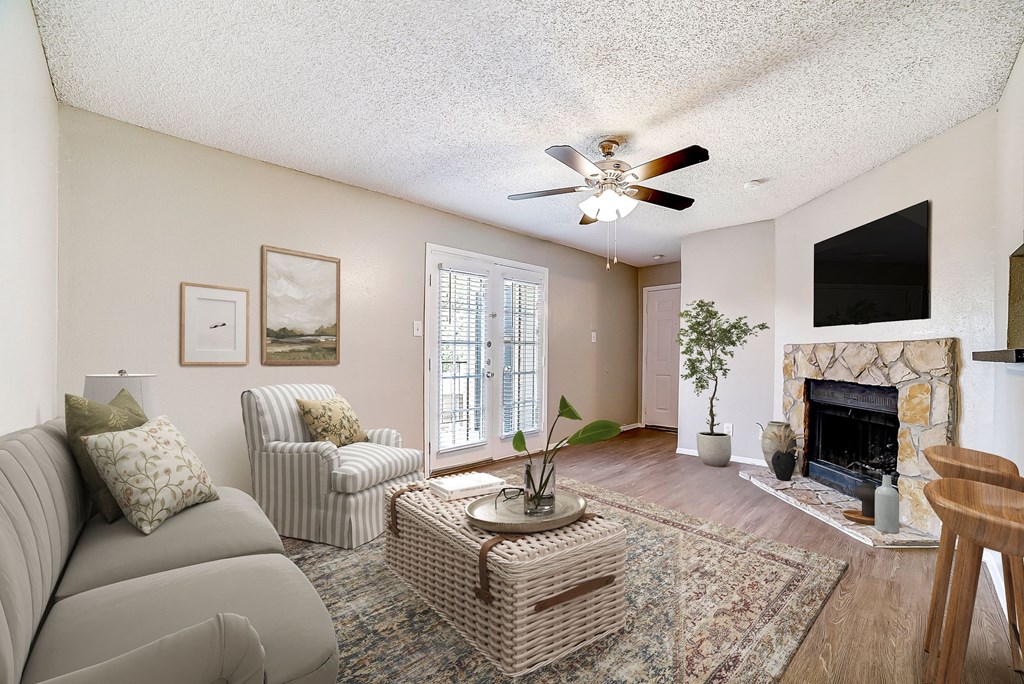 a living room with a fireplace and a ceiling fan