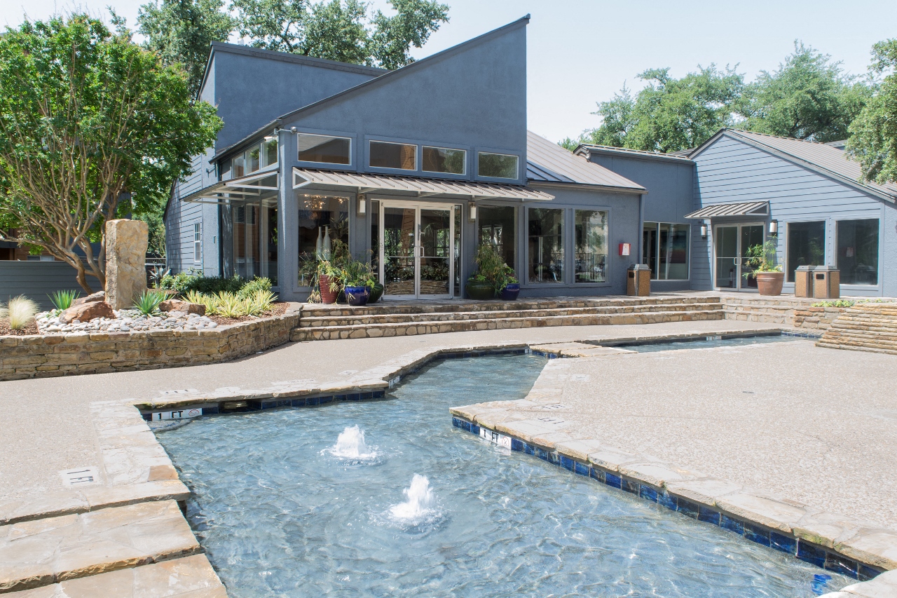 a pool and spa in front of a house