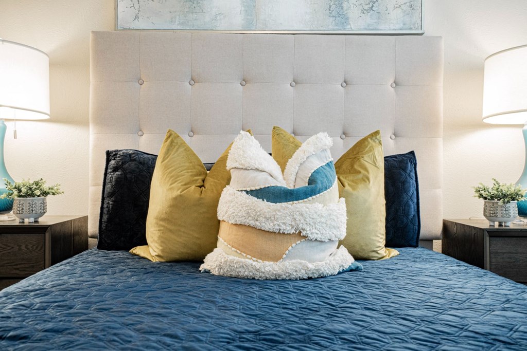 a bedroom with a bed with pillows and a blue blanket at Aero White Rock, Dallas, TX, 75238
