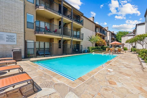 Swimming pool with sundeck and lounge chairs at Hidden Ridge Apartments, Irving, Texas