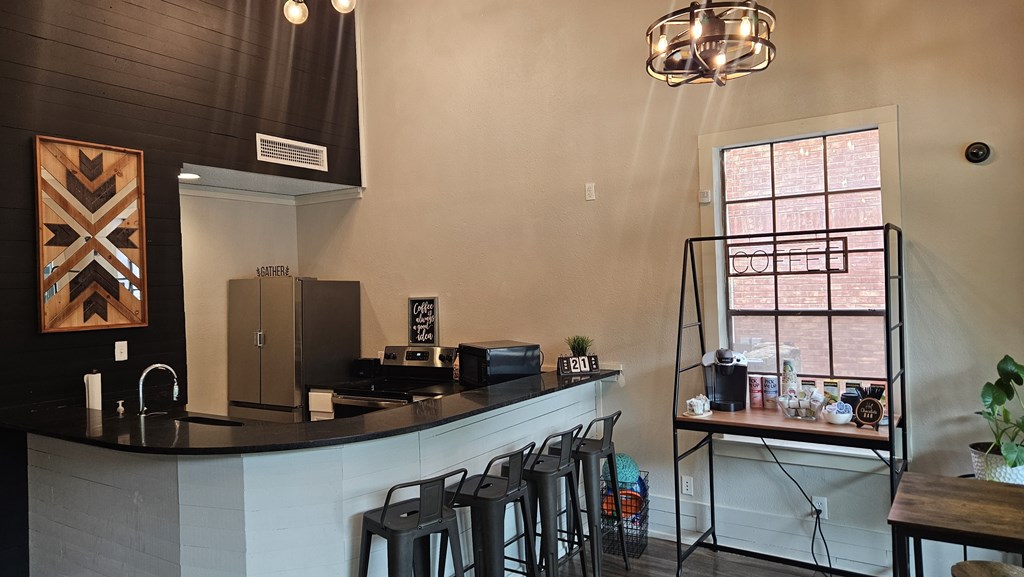 A kitchen with a black counter top and a white wall.