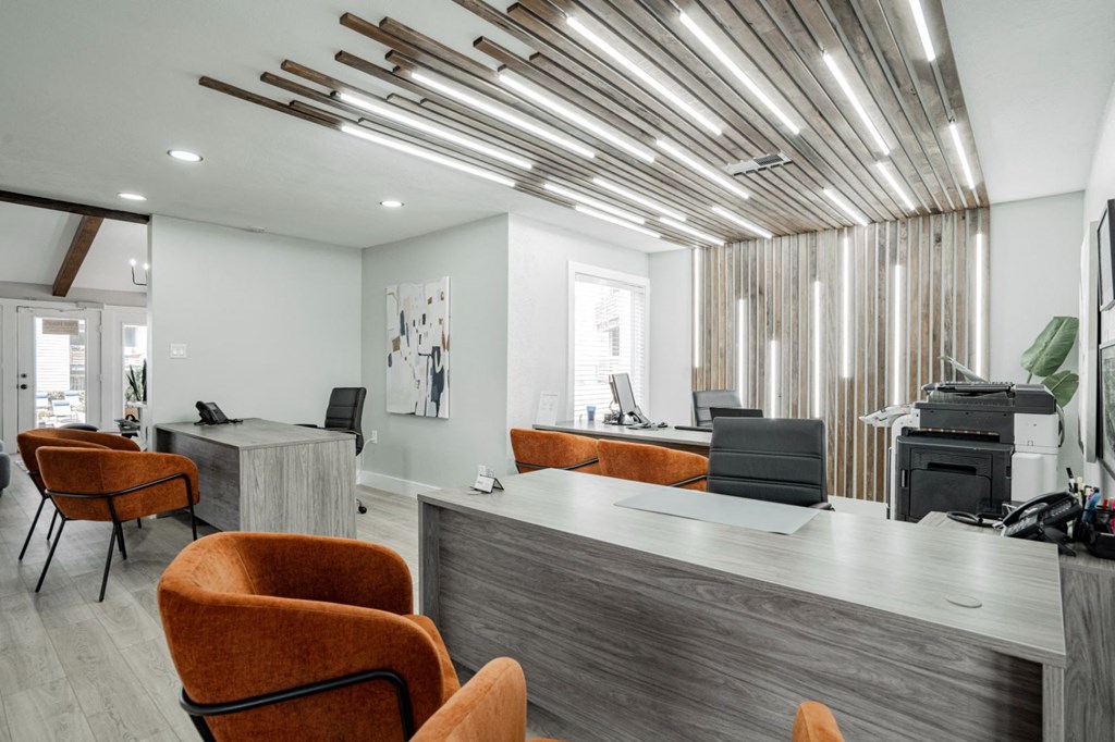 a lobby with orange chairs and a reception desk