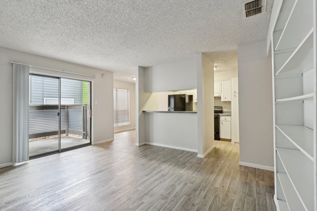 an open living room and kitchen with a sliding glass door