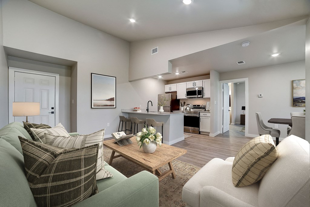 a living room with couches and a coffee table in front of a kitchen at The Frederick, San Antonio