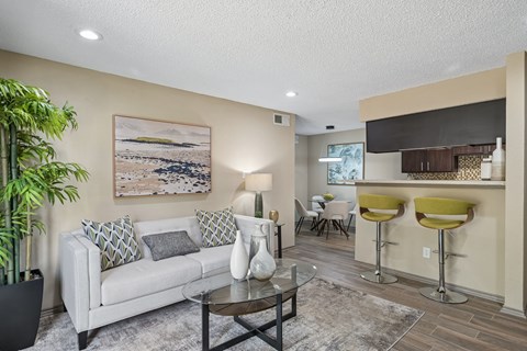 A living room with a white couch, a coffee table, and a painting on the wall.