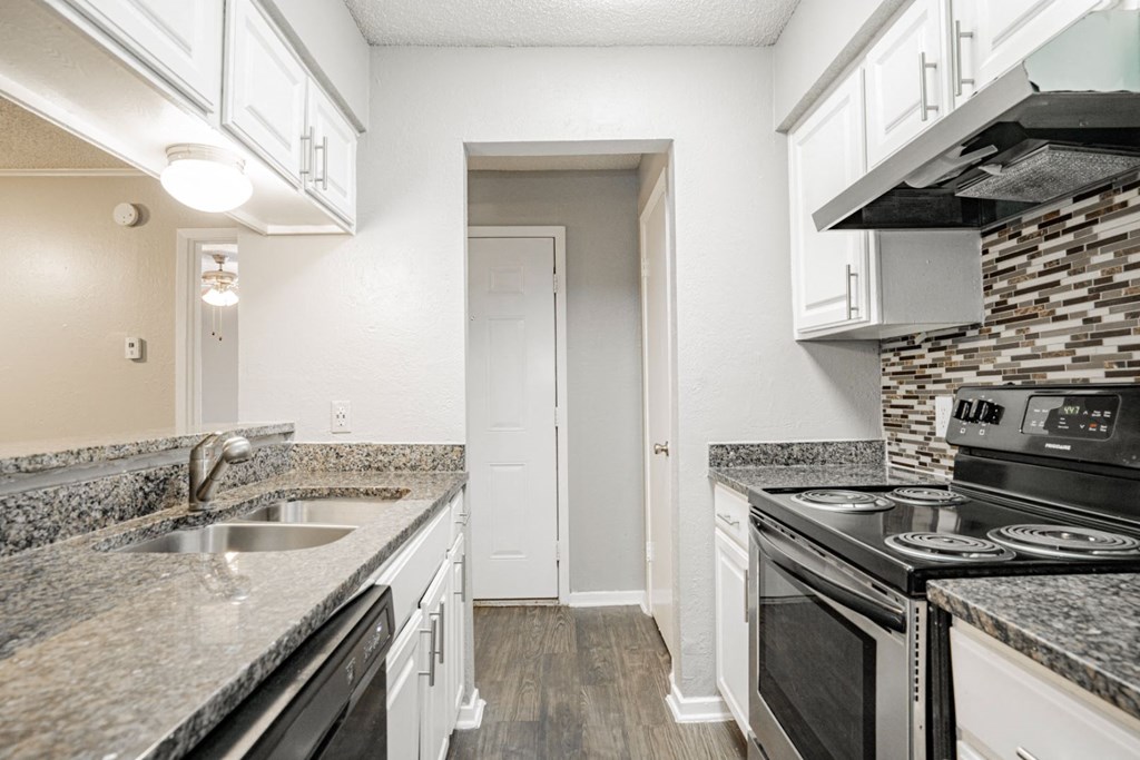 a kitchen with granite counter tops and black appliances