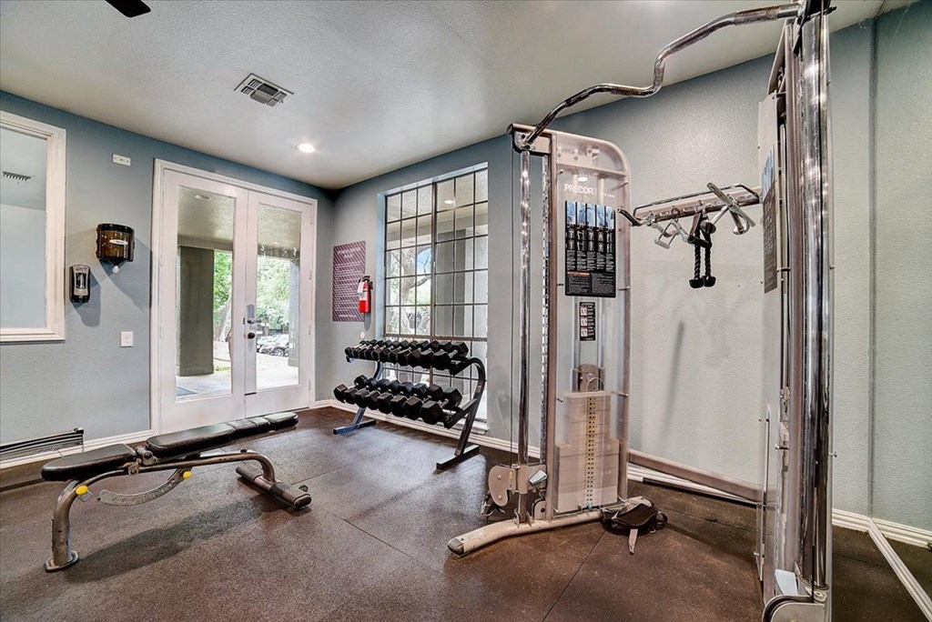 the gym has plenty of equipment and a large window