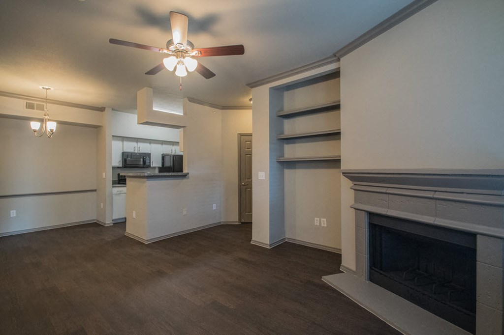 a living room with a fireplace and a ceiling fan