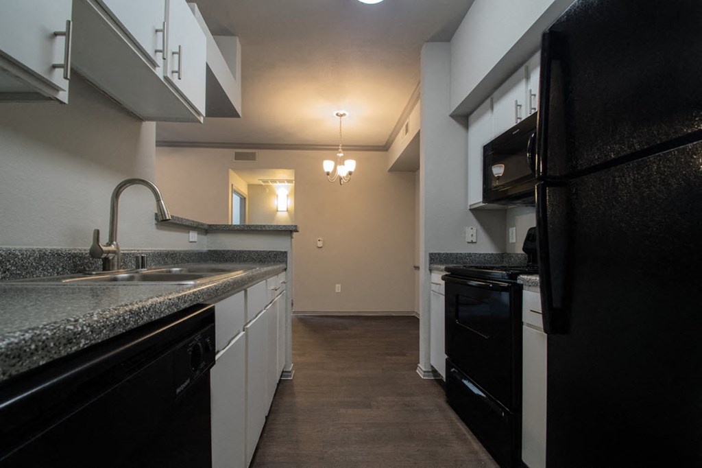 a kitchen with black appliances and granite counter tops
