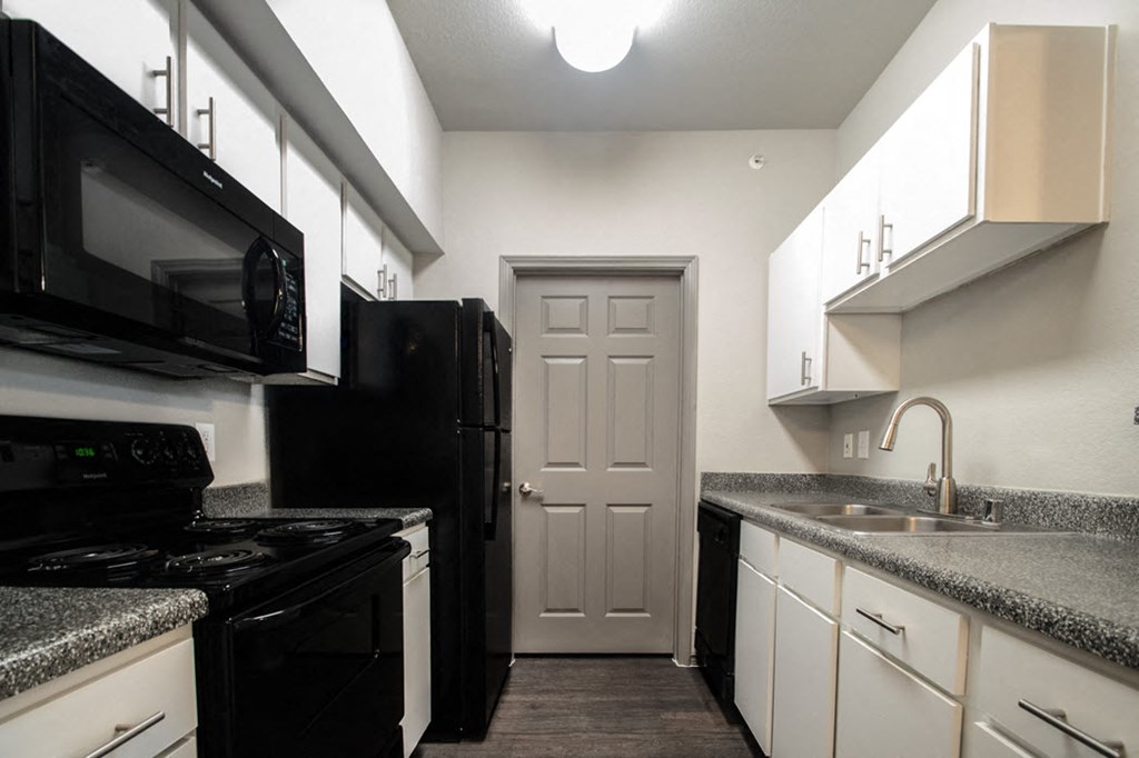 a kitchen with black appliances and granite counter tops
