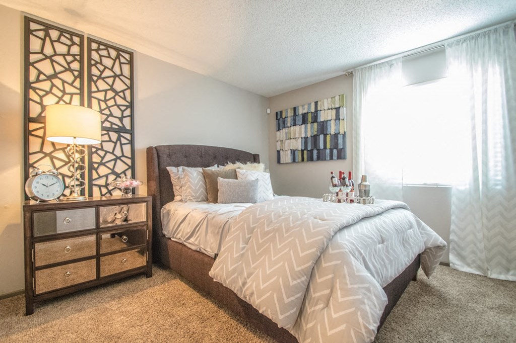 a bedroom with a bed and a dresser and a window