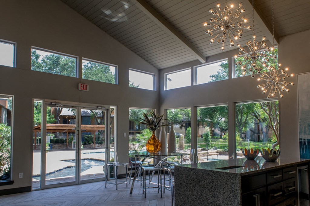 the lobby of a building with large windows and a table with chairs
