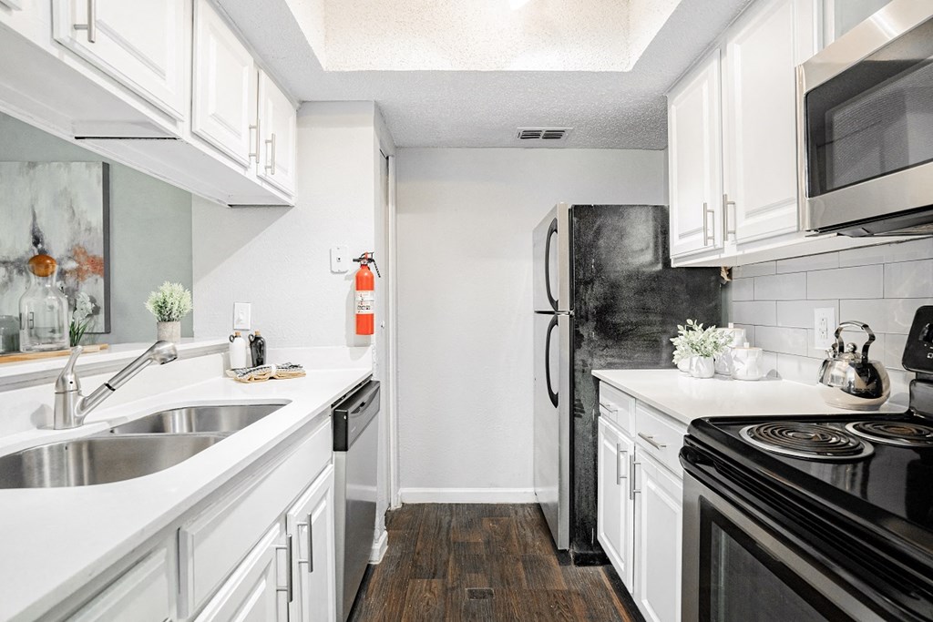 a renovated kitchen with white cabinets and black appliances