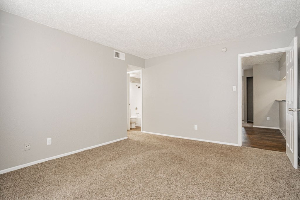 an empty living room with white walls and carpet
