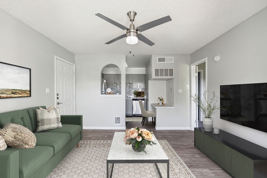 a living room with a ceiling fan and a green couch