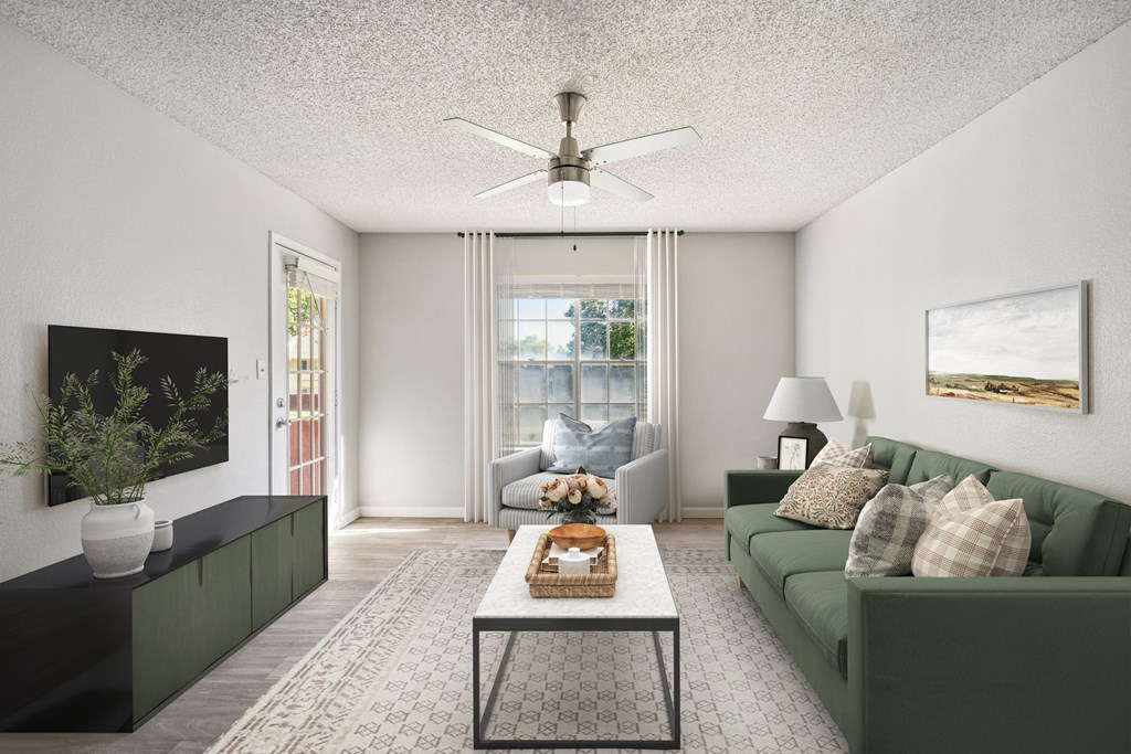 a living room with a green couch and a ceiling fan