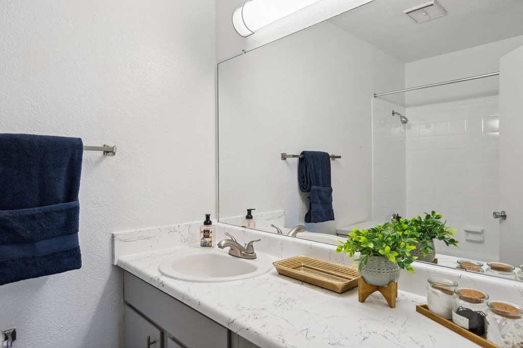a white bathroom with a sink and a mirror