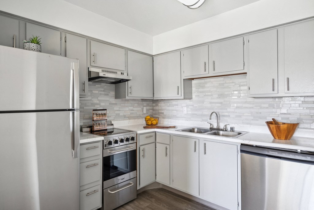 a white kitchen with stainless steel appliances and white cabinets