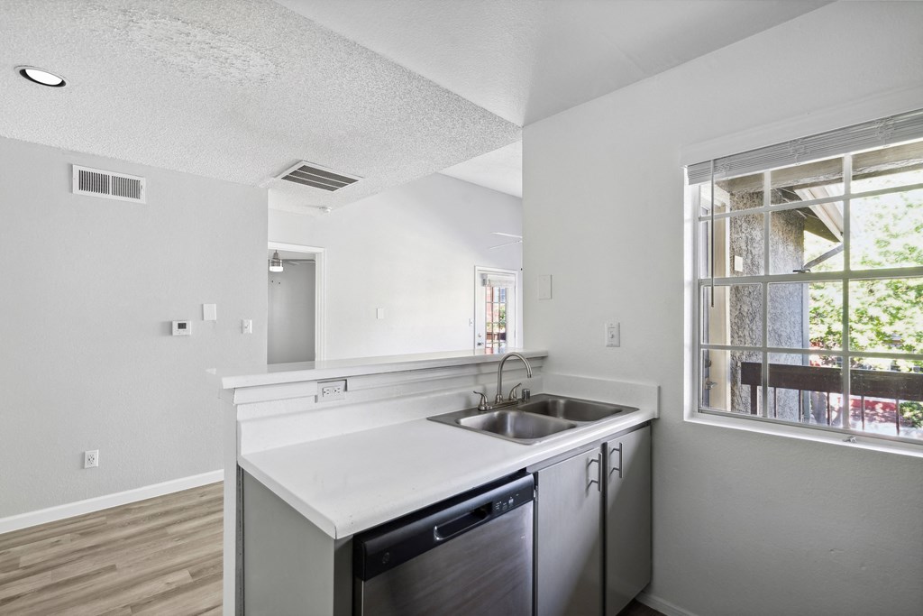 an empty kitchen with a sink and a window