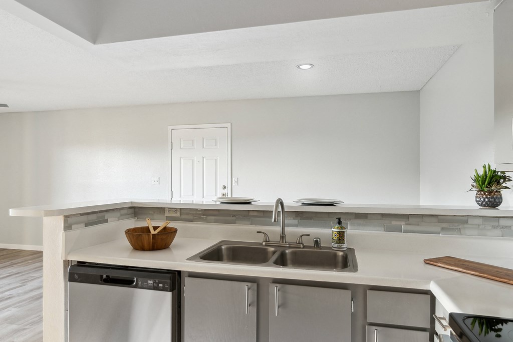 an empty kitchen with stainless steel appliances and a sink