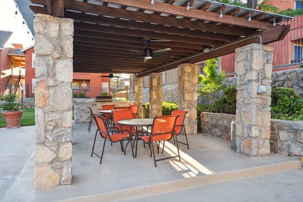 a patio with a table and chairs under a pergola