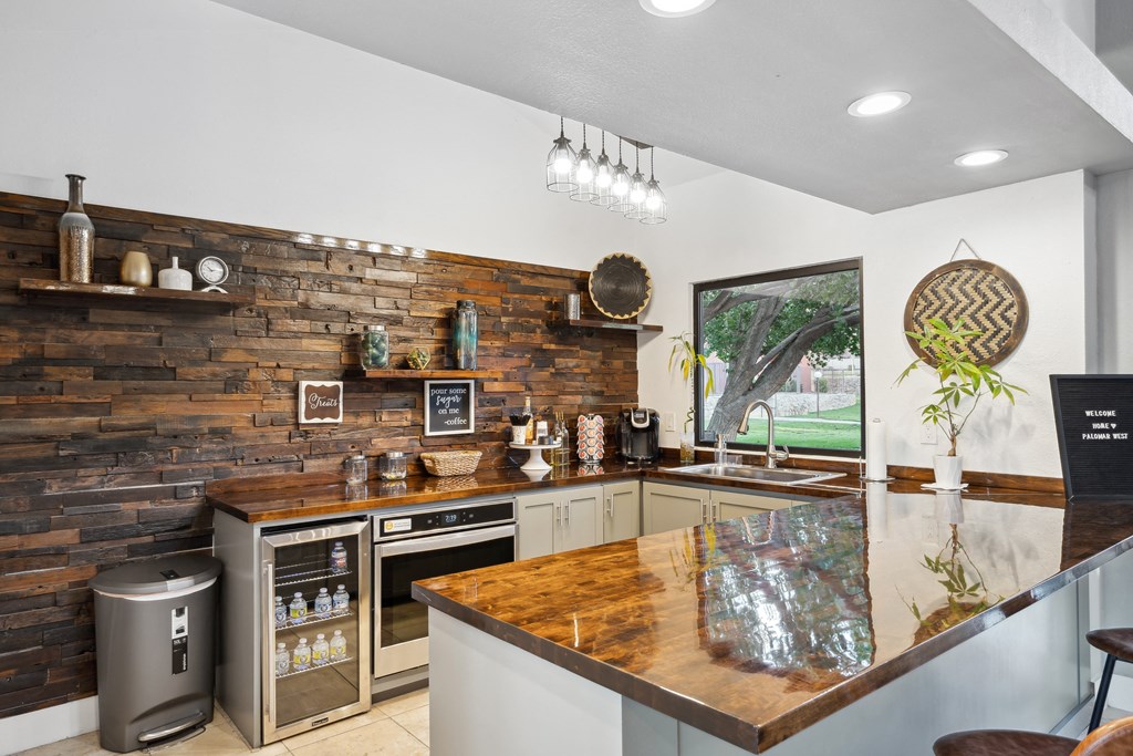 the kitchen has a large island with a wooden counter top