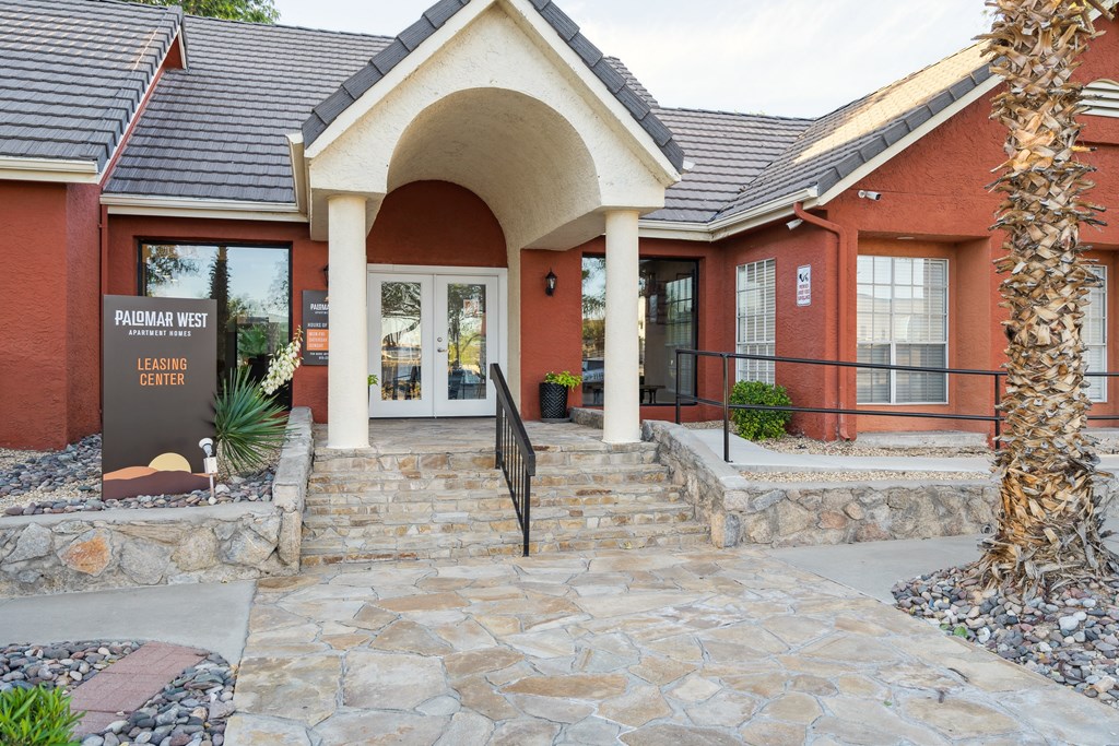 the front of a brick building with a stone walkway and steps