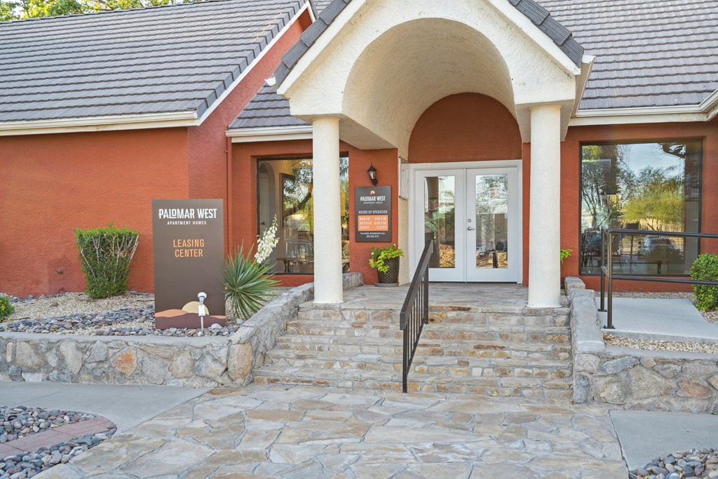 the front entrance of a building with steps and an umbrella in front of it