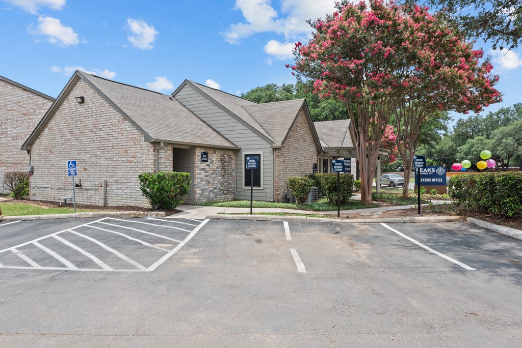 a parking lot with a brick building in the background
