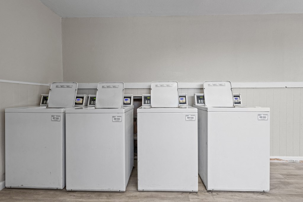 a row of washers and dryers in a laundry room