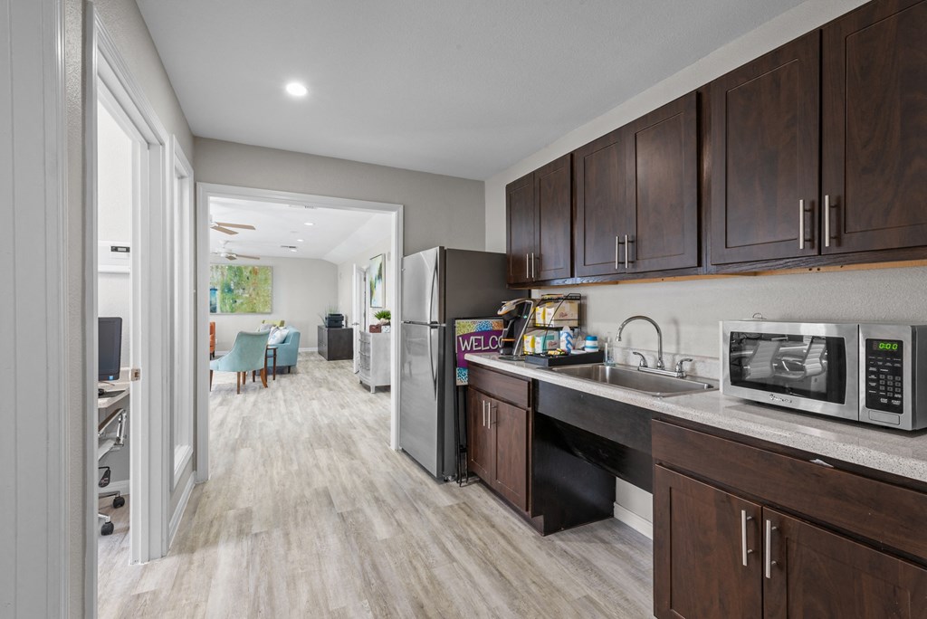 a kitchen with dark wood cabinets and stainless steel appliances