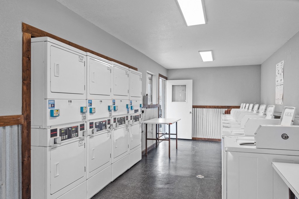 a room with white cabinets and a table with a laptop on it