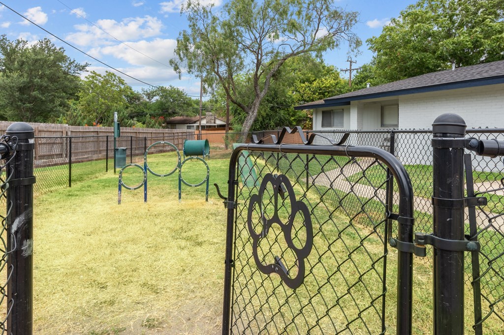 a backyard with a playground and a house in the background