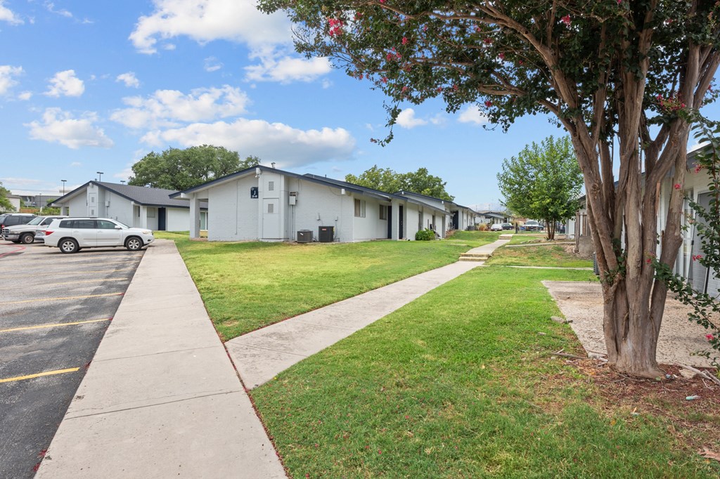 a row of houses with cars parked in front of them