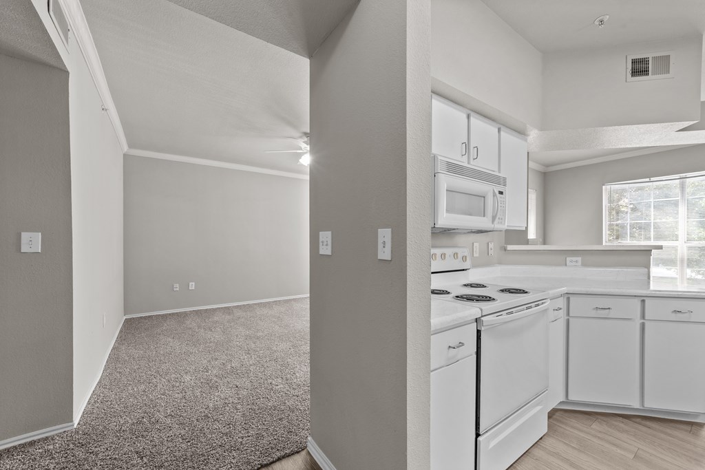 A kitchen with white appliances and cabinets.