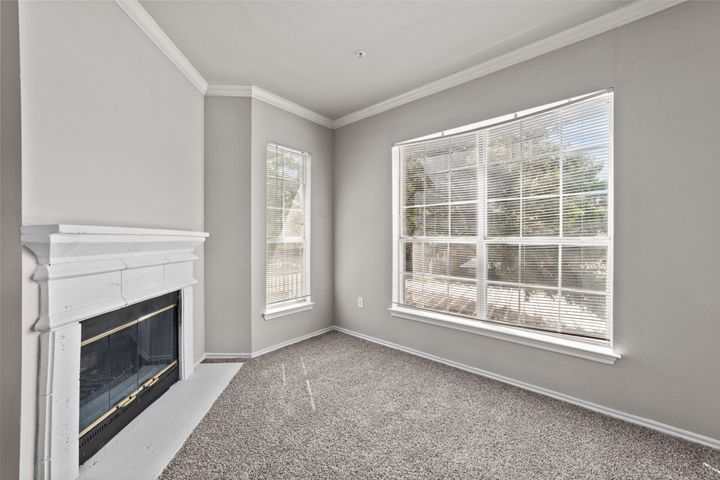 A room with a fireplace and a window with blinds.