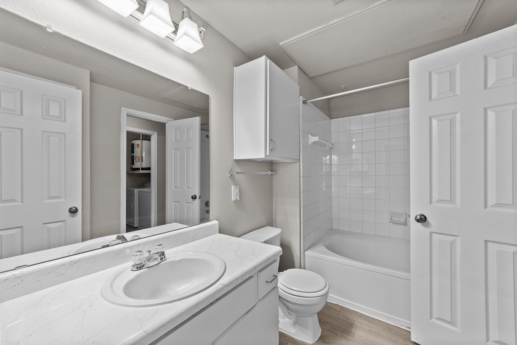 A white bathroom with a sink, toilet, and bathtub.