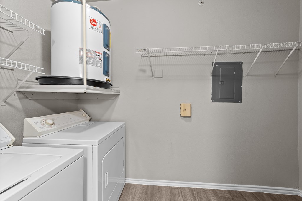 A laundry room with a washer and dryer on the shelves.