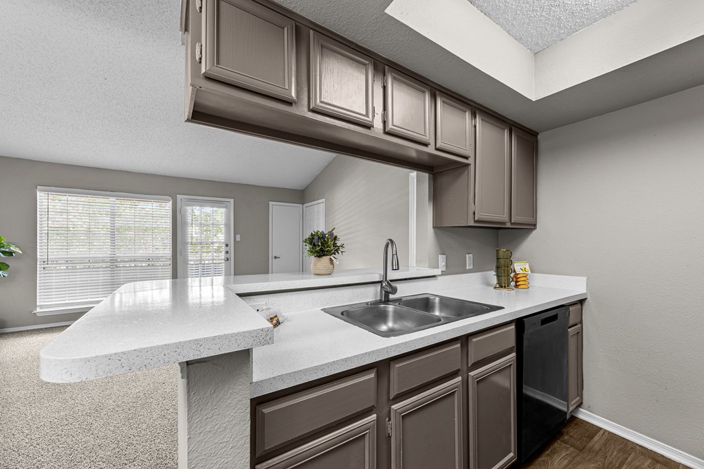 A kitchen with brown cabinets and a white countertop.
