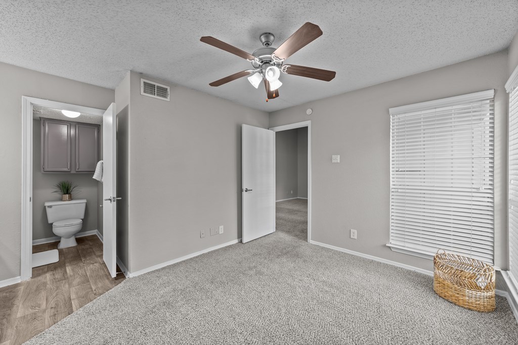 A room with a ceiling fan and a carpeted floor.