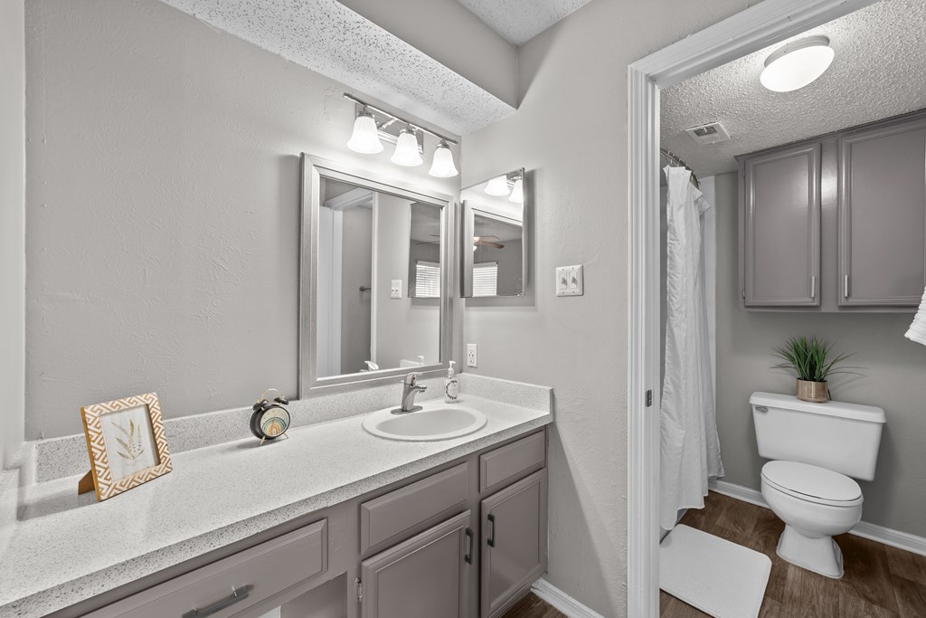A bathroom with a white sink and a white toilet.