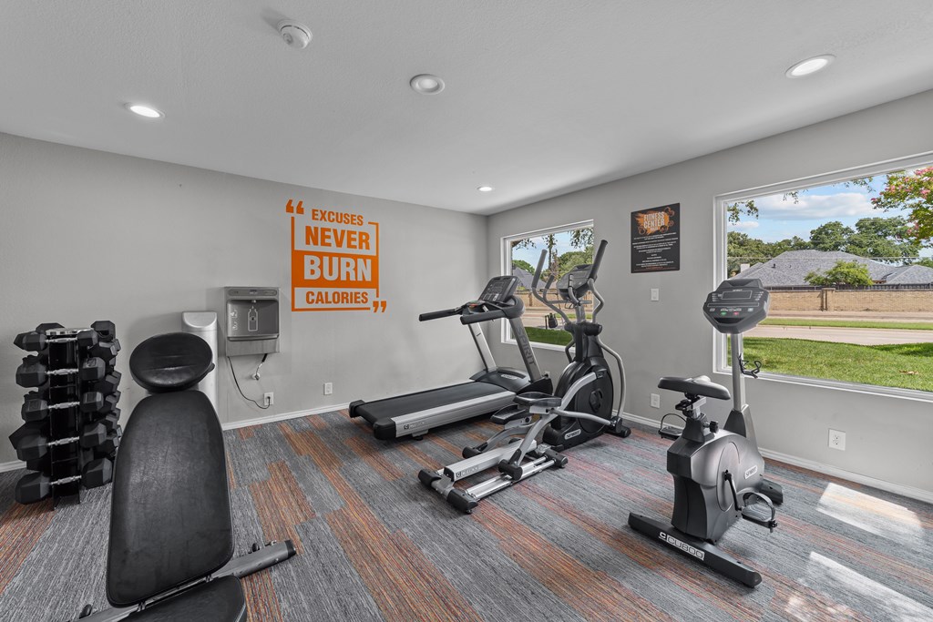 A gym room with a sign that says "Excuses Never Burn Calories".