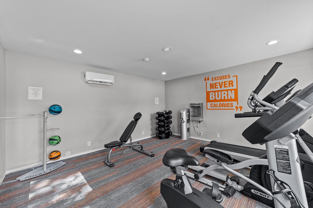 A gym room with a row of exercise bikes and a sign that says
