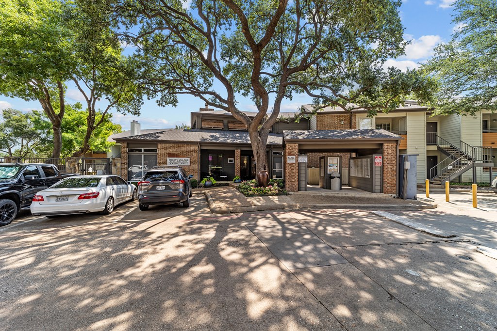 A parking lot with cars and a building in the background.