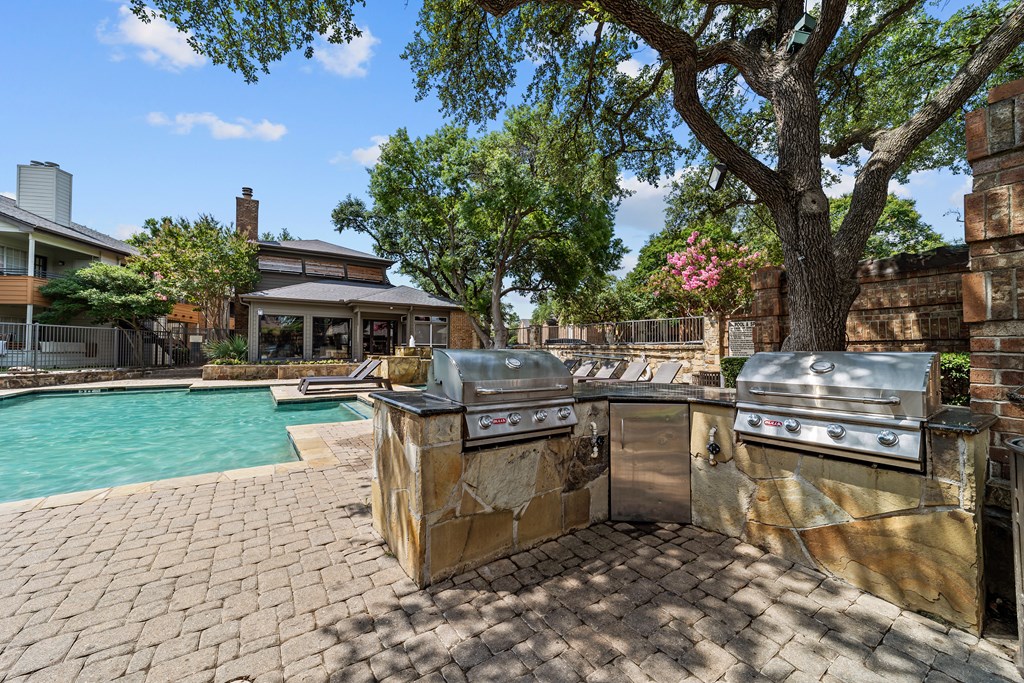 A backyard with a grill and a pool.
