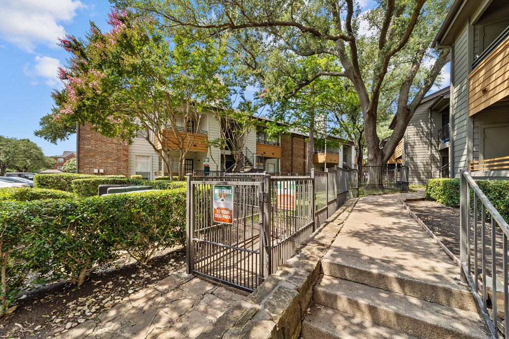A gated entrance to a residential area with a sign on the gate.